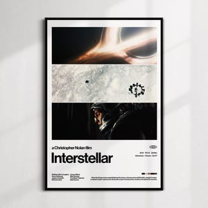 Puede incluir: Un póster enmarcado de la película "Interstellar". El póster presenta tres paneles horizontales con imágenes espaciales, incluyendo un agujero negro y una nave espacial. El título de la película está en texto blanco en negrita, con el nombre del director encima.