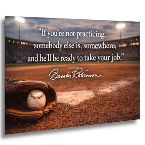 May include: A brown leather baseball glove holding a white baseball with red stitching on a dirt field. The text reads: "If you're not practicing, somebody else is, somewhere, and he'll be ready to take your job." followed by Brooks Robinson.