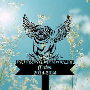 May include: Black metal garden stake featuring a pug with angel wings, running through grass. The text reads "IN LOVING MEMORY OF Orion 2014-2024". The background is a soft blue with white flowers.