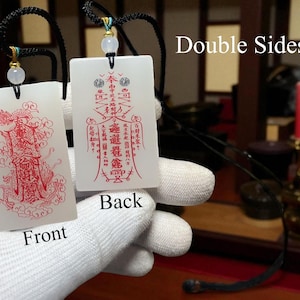 May include: Two white rectangular pendants with red Chinese characters and illustrations. Each pendant is attached to a black cord with a small bead. One pendant is labeled "Front" and the other "Back". The text "Double Sides" is also visible.