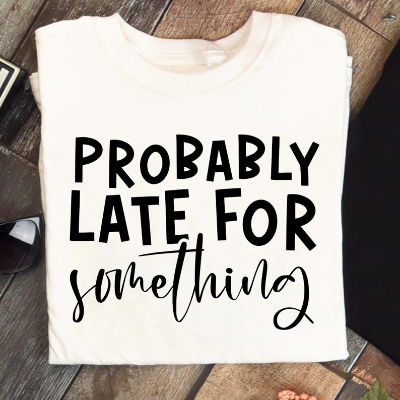 K&ouml;nnte beinhalten: Ein wei&szlig;es T-Shirt mit dem schwarzen Aufdruck "PROBABLY LATE FOR something". Der Text ist fett gedruckt, das Wort "something" ist kursiv geschrieben. Das T-Shirt ist gefaltet.