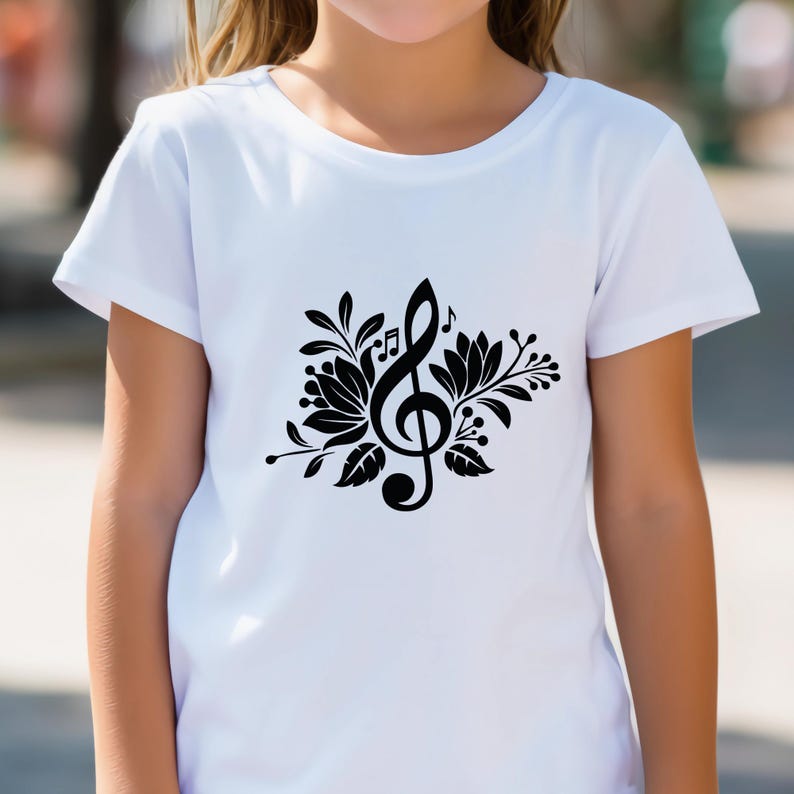 May include: White t-shirt featuring a black floral design with a treble clef and musical notes. The graphic is centered on the shirt, creating a visually appealing design. The shirt is made of a soft, comfortable material.