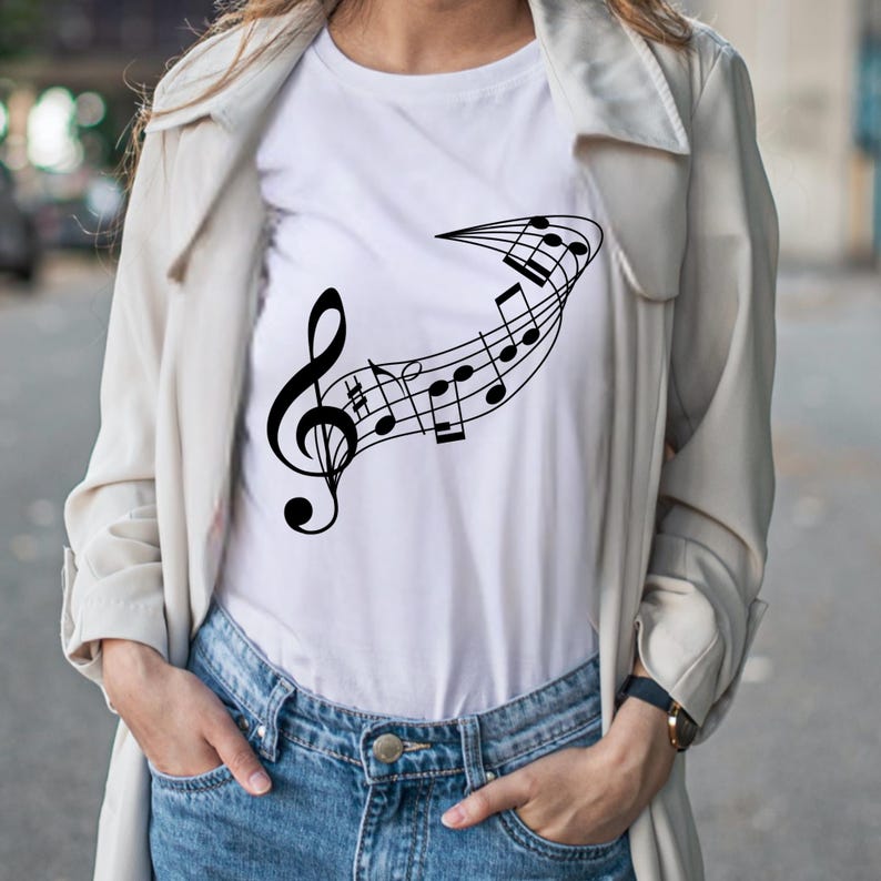 May include: White t-shirt featuring a black musical note design. The design includes a treble clef and musical notes flowing across the shirt. The shirt is made of a soft material and is suitable for casual wear.