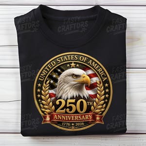 K&ouml;nnte beinhalten: Ein schwarzes T-Shirt mit einem kreisf&ouml;rmigen Motiv, das einen Wei&szlig;kopfseeadler, die amerikanische Flagge und goldene Lorbeerbl&auml;tter zeigt. Der Text lautet UNITED STATES OF AMERICA, 250TH ANNIVERSARY und 1776-2026, mittig auf der Brust.