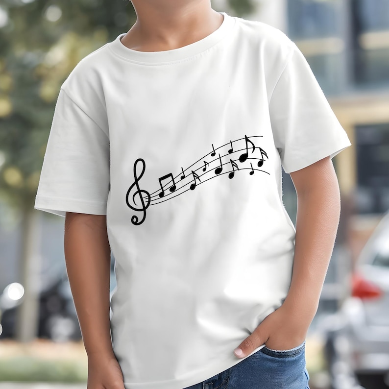 May include: White t-shirt featuring a black musical staff with a treble clef and musical notes. The design is printed on the front of the shirt. The shirt is short-sleeved and appears to be made of cotton.
