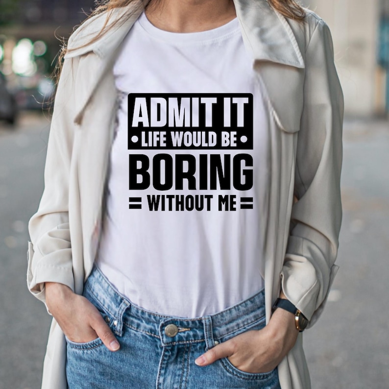 K&ouml;nnte beinhalten: Wei&szlig;es T-Shirt mit dem schwarzen Text "ADMIT IT &bull; LIFE WOULD BE &bull; BORING = WITHOUT ME =". Die Person tr&auml;gt dazu eine Jeans und eine hellfarbene Jacke.