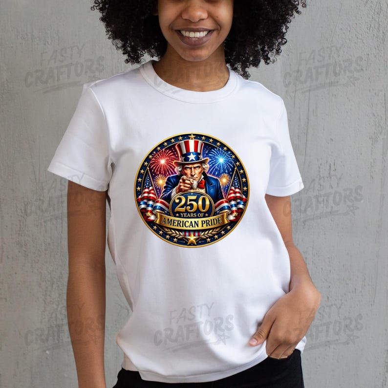 K&ouml;nnte beinhalten: Ein wei&szlig;es T-Shirt mit kurzen &Auml;rmeln und einem kreisf&ouml;rmigen Aufdruck von Uncle Sam, der nach vorne zeigt, umgeben von Feuerwerk und amerikanischen Flaggen. Der Text 250 YEARS OF AMERICAN PRIDE steht in goldenen Buchstaben auf einem Banner.