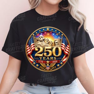 K&ouml;nnte beinhalten: Ein schwarzes T-Shirt mit einer kreisf&ouml;rmigen Grafik, die den Mount Rushmore, zwei amerikanische Flaggen und einen goldenen Adler zeigt. Der Text lautet 250 YEARS, 1776 und 2026. Das Design umfasst einen sternf&ouml;rmigen Rahmen und Feuerwerk.