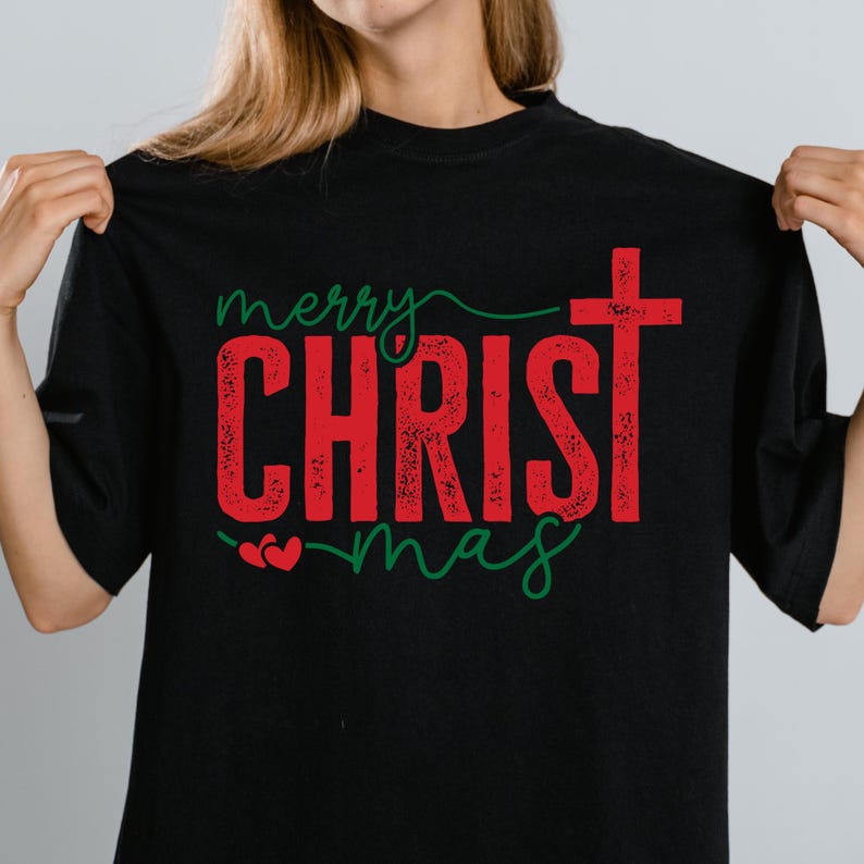 Puede incluir: Camiseta negra con las palabras "Merry CHRISTmas" en rojo y verde. La palabra "CHRIST" est&aacute; en negrita, con un efecto desgastado, y una cruz reemplaza la letra "T". La palabra "merry" est&aacute; escrita en cursiva.
