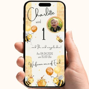 Könnte beinhalten: Ein Smartphone zeigt eine Geburtstagseinladung für "Charlotte", die 1 Jahr alt wird. Das Design zeigt Cartoon-Bienen, Luftballons und den Text "...und Ihr seid eingeladen!" und "Wir freuen uns auf Euch."