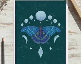 May include: A framed art print featuring a blue and teal moth with intricate wing patterns. The artwork includes phases of the moon, stars, and a diamond shape against a dark teal background. A pencil and decorative flowers are visible.