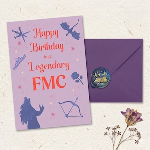 May include: A light purple birthday card with red text reading Happy Birthday to a Legendary FMC, surrounded by dark purple illustrations of a dragon, sword, tiara, rose, wolf, and bow. A matching purple envelope features a circular wax seal.