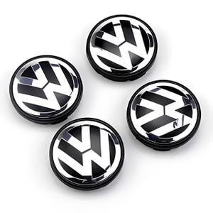 Op de afbeelding: Vier zwarte en zilveren wieldoppen met het Volkswagen-logo. De wieldoppen zijn rond met een zwarte basis en een zilveren embleem. Het Volkswagen-logo is een gestileerde 'W' in zilver tegen een zwarte achtergrond.