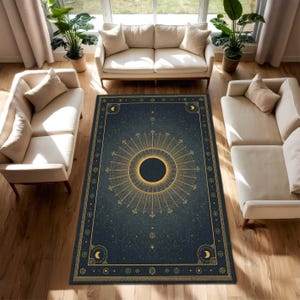Könnte beinhalten: Ein rechteckiger Teppich mit einem Himmelsdesign. Der Teppich hat einen dunkelblauen Hintergrund mit einem goldenen Sonnenstrahl-Design in der Mitte. Der Rand hat goldene Akzente mit Monden und Sternen. Der Teppich befindet sich in einem Wohnzimmer mit beigen Sofas und Pflanzen.