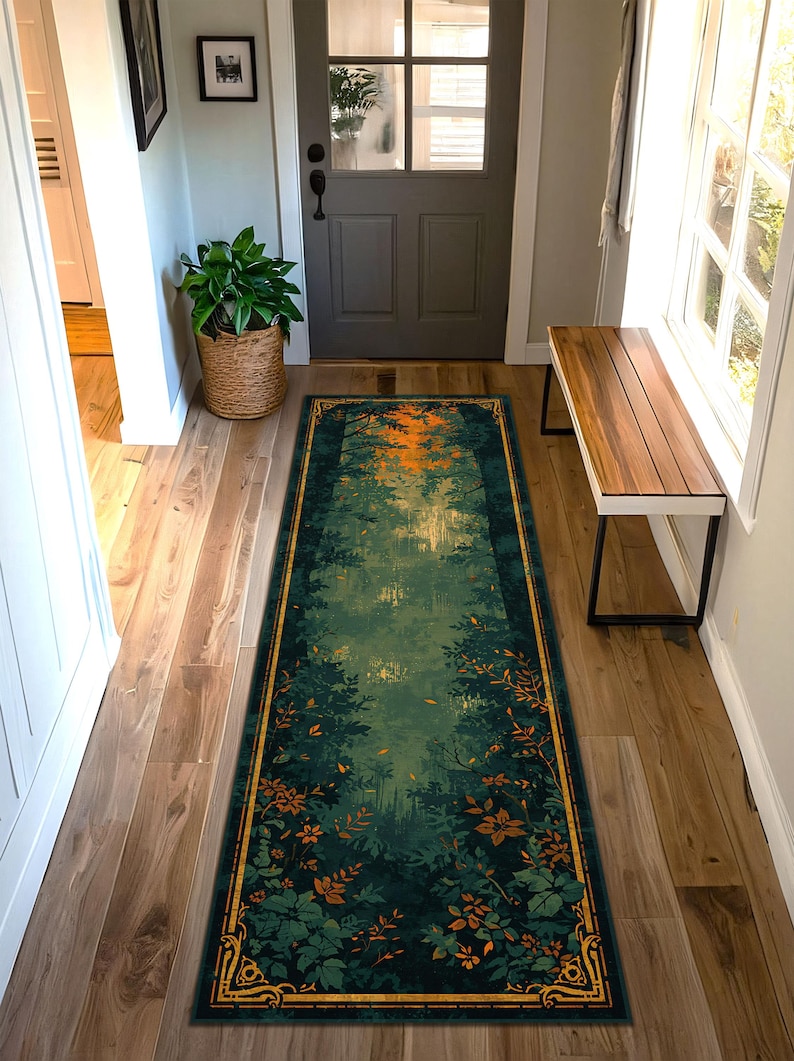 K&ouml;nnte beinhalten: Ein langer, rechteckiger Teppich mit einem Waldszenen-Design. Der Teppich hat eine dunkelgr&uuml;ne und t&uuml;rkisfarbene Farbpalette mit einem goldenen Rand. Das Design zeigt einen Wald mit B&auml;umen und Bl&auml;ttern sowie einen orange-gelben Himmel.