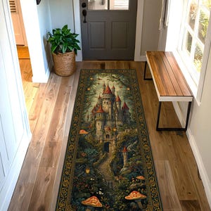 May include: A rectangular area rug featuring a detailed illustration of a fairytale castle with red-roofed towers, surrounded by lush greenery, mushrooms, and a winding path. The rug has a dark green border with ornate gold detailing.