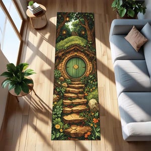 May include: A rectangular yoga mat featuring a whimsical illustration of a hobbit door set into a hillside. The door is green, surrounded by a stone facade, and leads to a path. The mat is decorated with trees, flowers, and a winding stone staircase.
