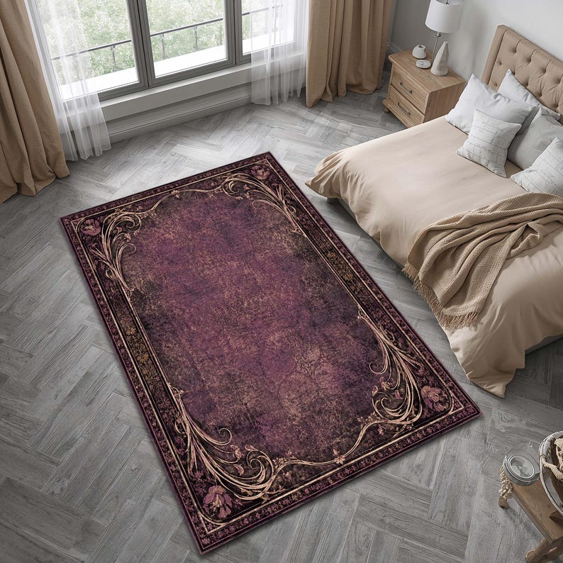 May include: A rectangular area rug featuring a deep plum and dark purple distressed base with a prominent ornate border. The border displays intricate gold and tan scrolling floral motifs and leaf patterns that frame the central field.