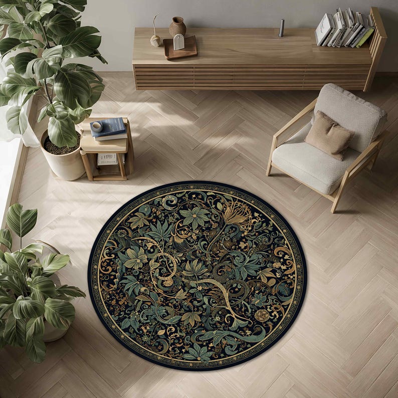 Op de afbeelding: Een ronde vloerkleed met een gedetailleerd bloemenontwerp in groen, goud en blauw op een zwarte achtergrond. Het vloerkleed ligt op een lichtgekleurde houten vloer, met een stoel en een houten kast op de achtergrond.