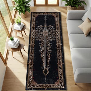 May include: A rectangular black rug with a gold sword and tree design. The rug has a gold border with Celtic knot patterns. The sword design is centered, with a tree-like pattern extending from the hilt. The rug is placed on a wooden floor.