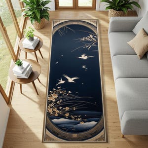 Könnte beinhalten: Ein rechteckiger Teppich mit dunkelblauem Hintergrund, der weiße Vögel im Flug und florale Akzente zeigt. Der Teppich hat einen goldenen Rand und ein Bogendesign oben und unten. Er liegt auf einem Holzboden.