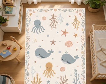 Può includere: Un tappeto rettangolare con sfondo crema, decorato con un tema oceanico. Presenta balene blu, polpi, stelle marine e conchiglie. Il tappeto è bordato da un motivo di alghe e coralli in morbidi colori pastello.