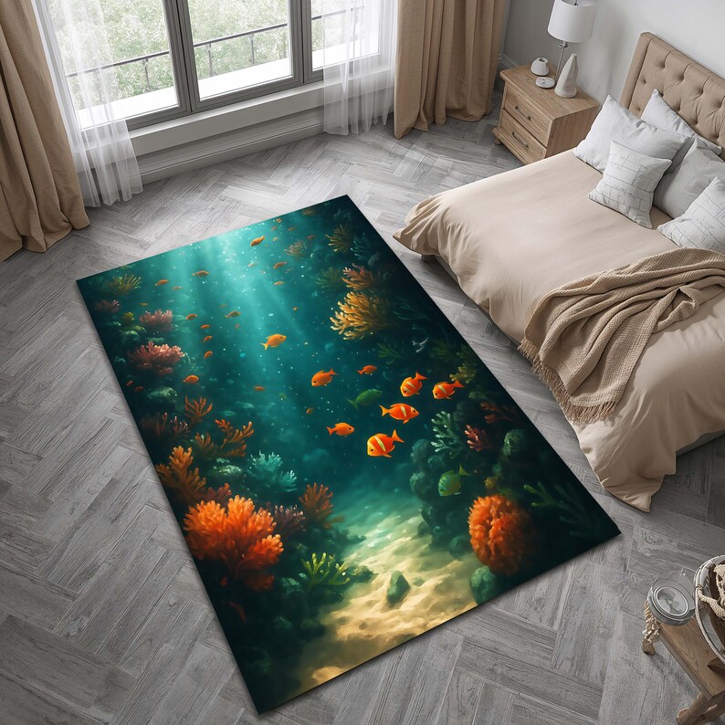 May include: A rectangular area rug featuring an underwater scene with orange fish, coral, and plants. The rug has a teal and blue background with light rays shining through the water. The rug is placed on a gray wooden floor.