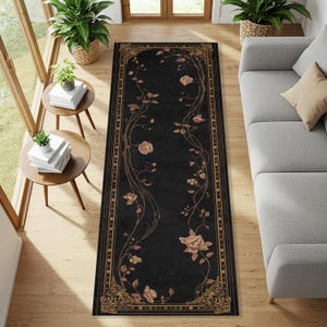 Puede incluir: Una alfombra rectangular negra con un diseño floral. La alfombra presenta un borde y detalles florales en tonos dorados y bronceados. El patrón floral incluye rosas y vides, creando un elegante revestimiento para el suelo.