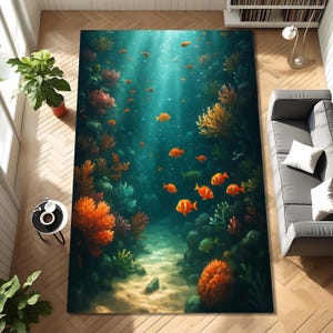 May include: A rectangular area rug featuring an underwater scene with orange fish, coral, and a sandy seabed. The rug's design includes shades of blue, green, and orange, creating a vibrant and immersive aquatic environment.