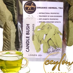 May include: A clear glass teacup and saucer filled with green tea, next to a package of dried candle bush leaves. The package has text that reads "Organic Herbal Tea" and "Candle Bush Dried Leaves". The image also includes loose dried leaves.
