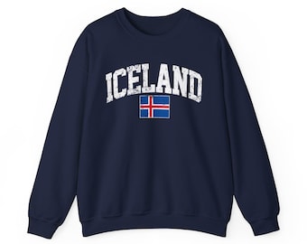 May include: Navy blue sweatshirt with the word "ICELAND" in distressed white lettering. Below the text is the Icelandic flag. The sweatshirt has long sleeves and a crew neck.