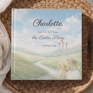 K&ouml;nnte beinhalten: Ein Kinderbuch mit dem Titel "Charlotte, Let Us Tell You the Easter Story - A Bunny's View." Das Cover zeigt eine pastellfarbene Landschaft mit einem Pfad, drei Kreuzen und zwei Hasenillustrationen. Das Buch liegt in einem geflochtenen Korb.