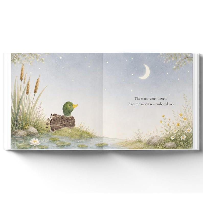 May include: An open children's book page featuring a watercolor illustration of a mallard duck sitting by a pond at night. The scene includes cattails, water lilies, and a crescent moon in a starry sky. The text reads: The stars remembered. And the moon remembered too.