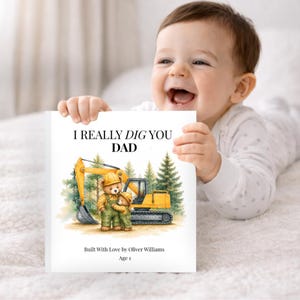 May include: A white book with the text "I REALLY DIG YOU DAD" and an illustration of two teddy bears and a yellow excavator. The book is held by a baby. The book also includes the text "Built With Love by Oliver Williams" and "Age 1".