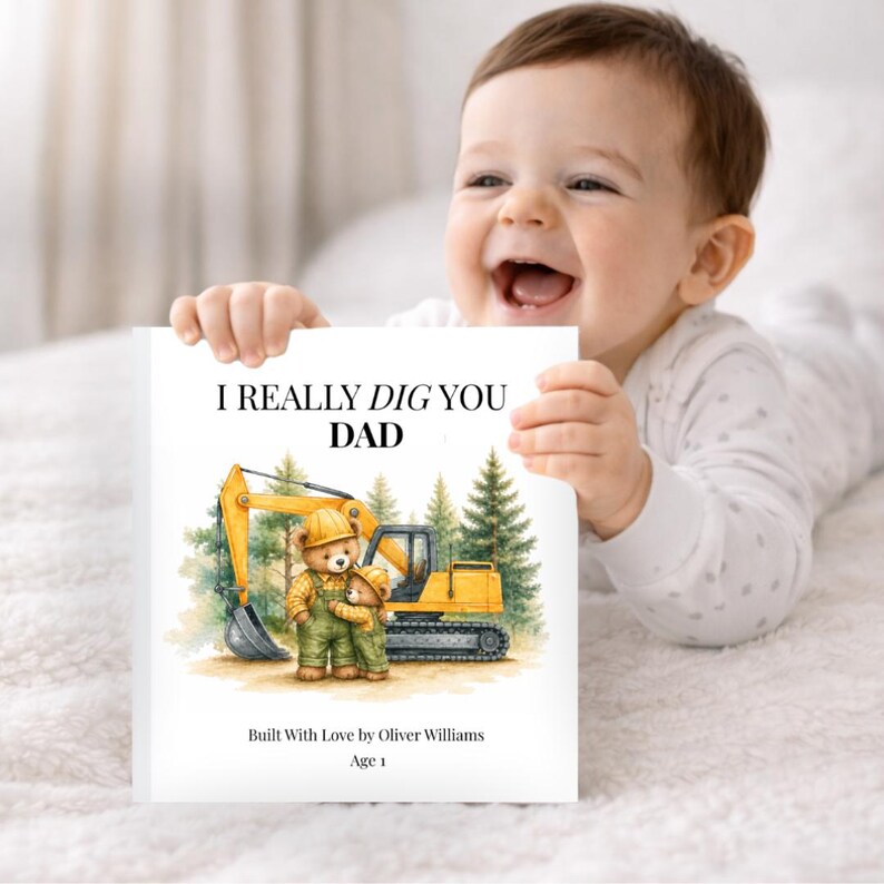 May include: A white book with the text "I REALLY DIG YOU DAD" and an illustration of two teddy bears and a yellow excavator. The book is held by a baby. The book also includes the text "Built With Love by Oliver Williams" and "Age 1".