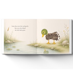 May include: An open children's book page featuring a watercolor illustration of a small duck standing by a pond. The text reads: Some days were slow and gentle. But every day helped the little duck grow. The duck has a green head and a textured body.