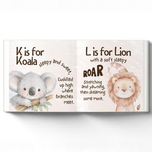 May include: An open book with animal illustrations. One page shows a koala with the text "K is for Koala." The opposite page features a lion wearing a nightcap, with the text "L is for Lion." The illustrations are in a soft, watercolour style.