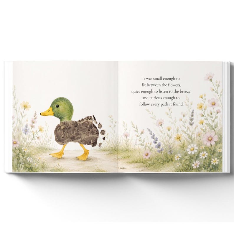 May include: An open children's book page featuring a watercolor illustration of a green and brown duckling walking through a field of wildflowers. The text reads: It was small enough to fit between the flowers, quiet enough to listen to the breeze, and curious enough to follow every path it found.