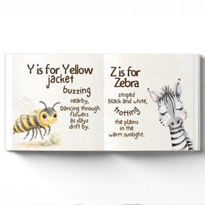 May include: An illustrated children's book open to two pages. The left page shows a yellow jacket bee with the text "Y is for Yellow jacket buzzing". The right page shows a zebra with the text "Z is for Zebra striped black and white".