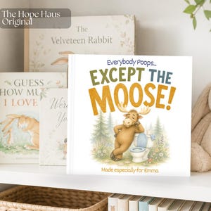 May include: A square children's book titled Everybody Poops... EXCEPT THE MOOSE! featuring an illustration of a brown moose leaning against a white toilet in a forest setting, with the text Made especially for Emma at the bottom of the cover.