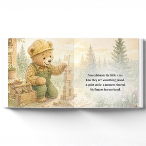 May include: A children's book illustration features a teddy bear wearing a construction hat and overalls, building a tower with wooden blocks. The text reads, "You celebrate the little wins...My fingers in your hand."