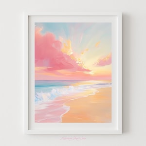 May include: A framed painting depicting a beach scene at sunset. The sky is filled with pink and yellow clouds, and the ocean is a mix of blue and white. The sand is a light peach colour, and the painting is in a white frame.
