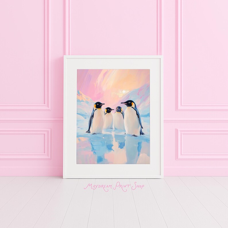 May include: A framed print featuring four penguins standing on a reflective surface, with a backdrop of a colorful sky and snow-covered mountains. The penguins have black heads, yellow accents, and white bodies. The print is in a white frame.