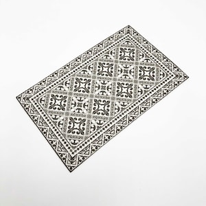 May include: A black and white patterned rug with a geometric design. The rug has a border with a floral motif.