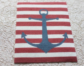 May include: A red and white striped fabric patch with a blue anchor in the center. The anchor is a nautical symbol.