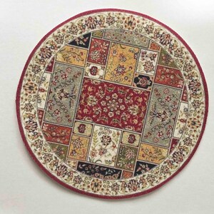 May include: A round, cream-colored rug with a red, beige, and green patterned design. The rug has a decorative border with floral motifs.
