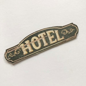 Letrero en miniatura de 'HOTEL' con aspecto desgastado y envejecido de madera vintage