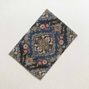 May include: A dark blue rug with a floral pattern in shades of red, yellow, and white. The rug has a central medallion with a geometric design.