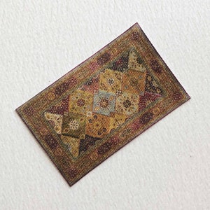 May include: A small, rectangular rug with a brown, beige, and red patterned design. The rug has a geometric pattern with a central design that resembles a stylized flower.