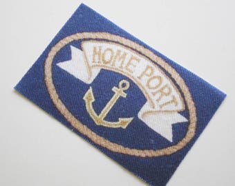 May include: A blue fabric patch with a white banner that says "Home Port" in gold lettering. A gold anchor is centered on the banner.